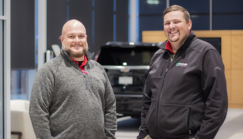 Two McGrath service techs stand in the service bay